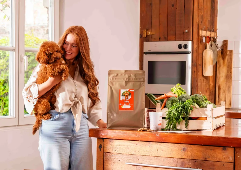 Vrouw met hond in de keuken met Just Russel voeding